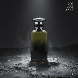 Black Fume perfume bottle on dark rocks